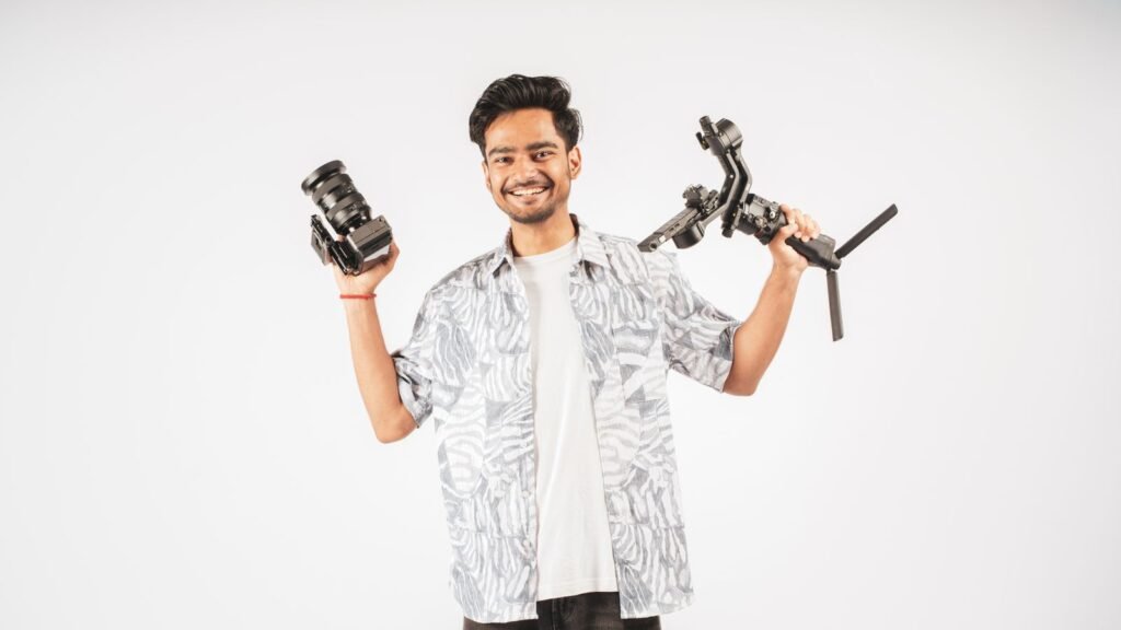 Smiling Indian content creator holding a camera and gimbal